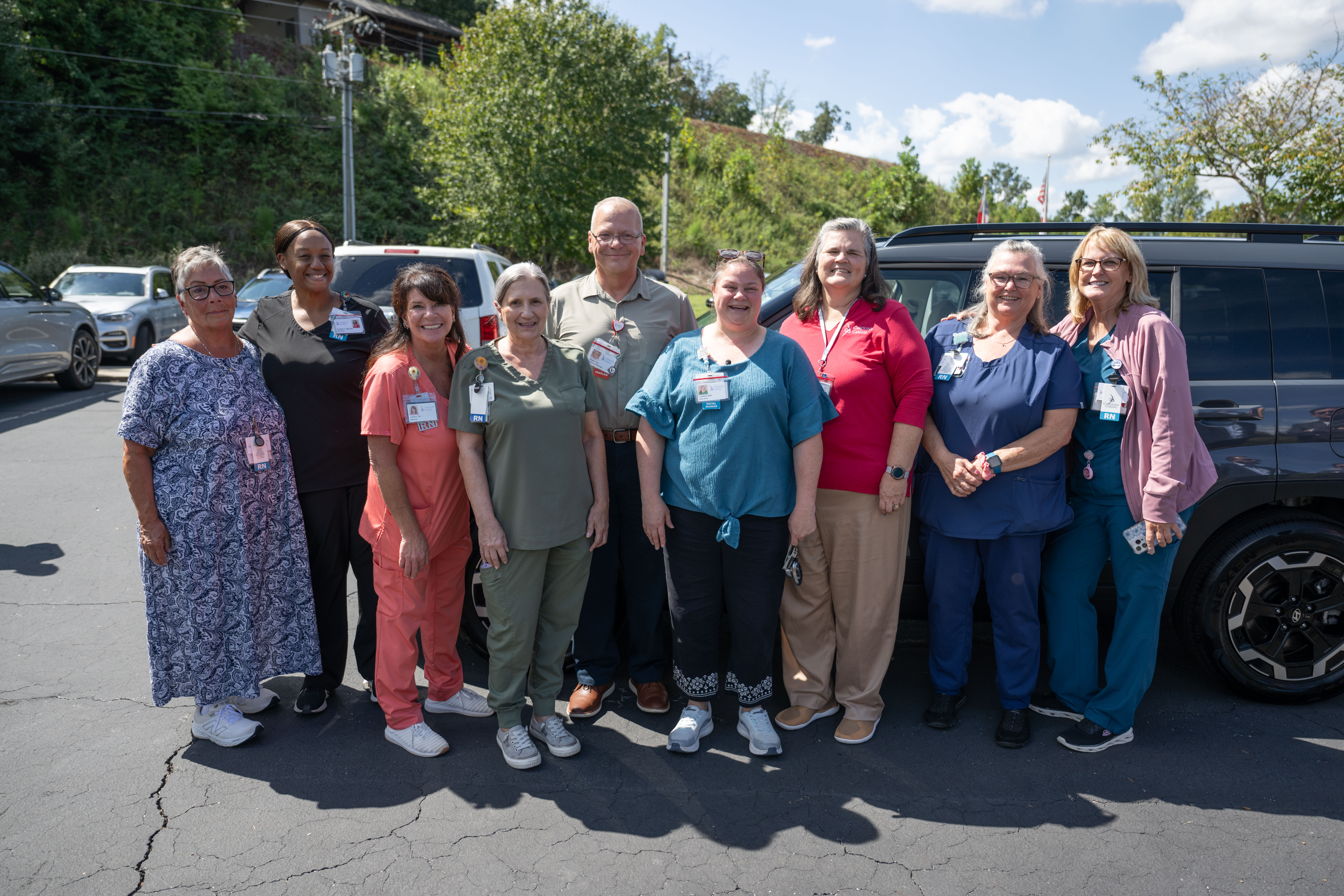 Staff gather around new Hyundai car to celebrate Christie Mullins, Carolina Caring Social Worker & Hyundai Hometown Hero